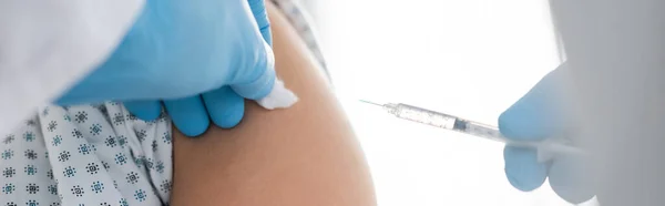 Partial view of doctor in latex gloves doing vaccination of woman in hospital, banner — Stock Photo