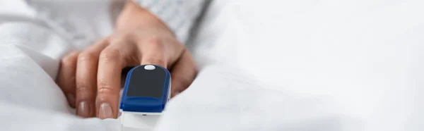 Cropped view of woman with pulse oximeter on finger, banner — Stock Photo