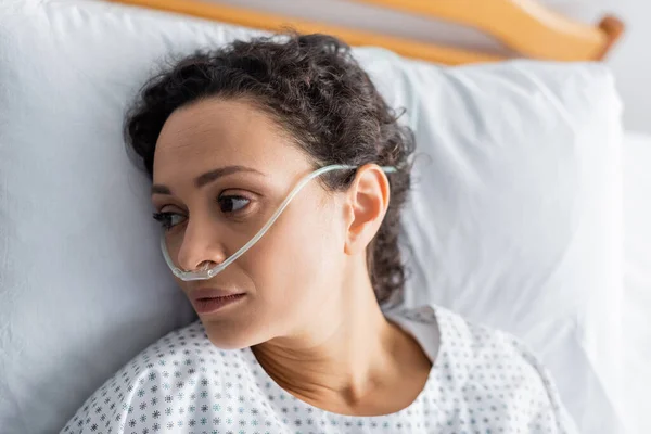 Draufsicht auf kranke Afroamerikanerin, die mit Nasenkanüle im Krankenhaus liegt — Stockfoto