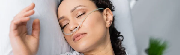 Над головой вид на больную африканскую американку с носовой канюлей, спящую в больничной койке, баннер — стоковое фото