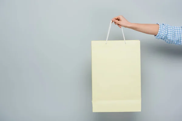 Visão parcial da mulher com saco de compras em fundo cinza com espaço de cópia — Fotografia de Stock