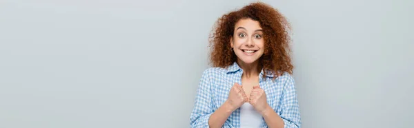 Aufgeregte Frau zeigt Hoffnungsgeste mit geballten Fäusten auf grauem Banner — Stockfoto