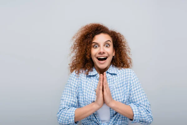 Mujer emocionada mostrando por favor gesto mientras mira la cámara aislada en gris — Stock Photo