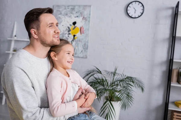 Feliz padre abrazando al niño en la sala de estar - foto de stock