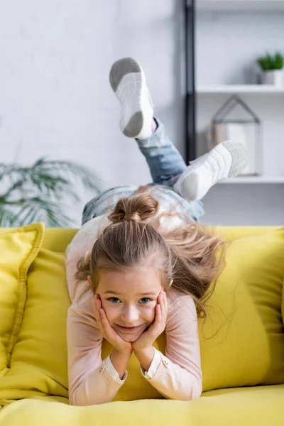 Smiling kid looking at camera on couch — Stock Photo