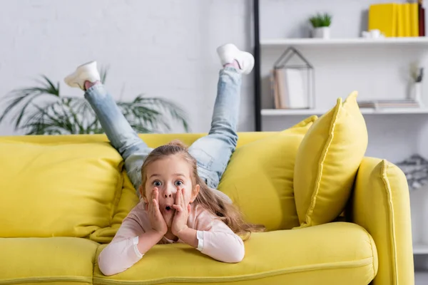 Amazed girl looking at camera in living room — Stock Photo