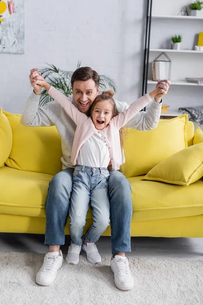 Pai e criança sorrindo para a câmera enquanto segurando as mãos — Fotografia de Stock