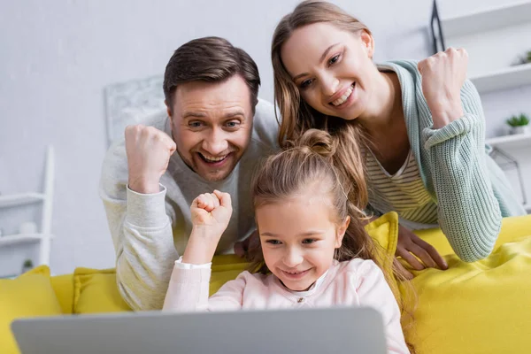 Famille montrant un geste oui en utilisant un ordinateur portable sur le premier plan flou — Photo de stock