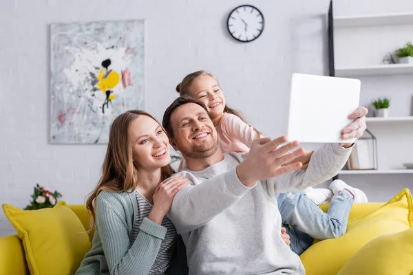 Усміхнена сім'я використовує цифровий планшет на розмитому передньому плані вдома — стокове фото