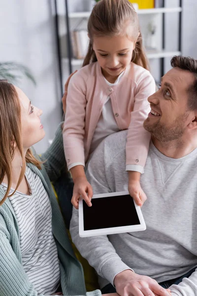 Tavoletta digitale con schermo bianco nelle mani di un bambino vicino a genitori positivi — Stock Photo