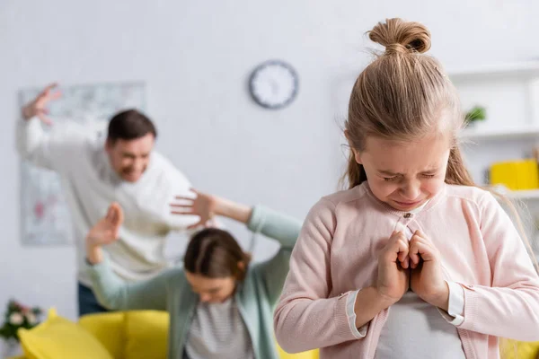 Niño llorando mientras padre discute con mamá en la sala de estar - foto de stock