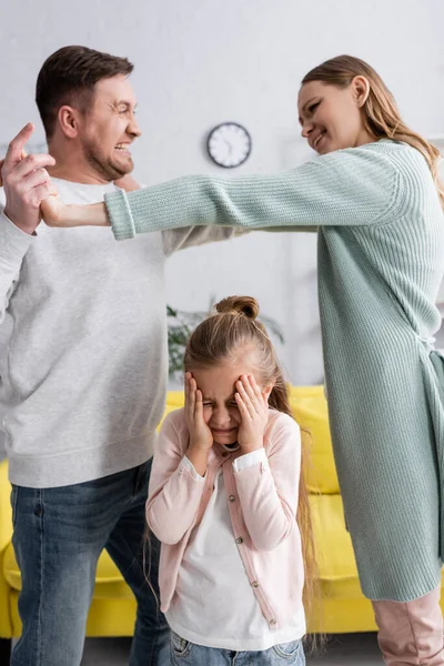 Blurred parents fighting near scared kid at home — Stock Photo