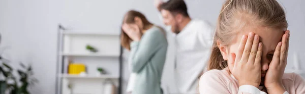 Menina cobrindo rosto com as mãos perto de pais brigando no fundo borrado, banner — Fotografia de Stock