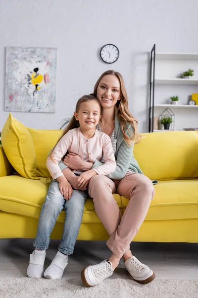 Sonriente madre mirando a la cámara mientras abraza al niño - foto de stock