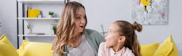 Verblüffte Mutter und Kind schauen einander an, Banner — Stockfoto