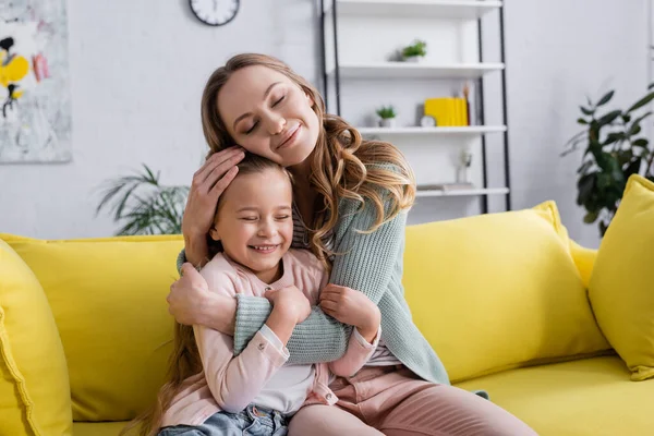 Happy mother with closed eyes embracing kid — Stock Photo