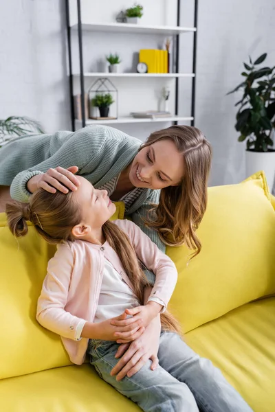 Mãe tocando e abraçando criança sorridente — Fotografia de Stock