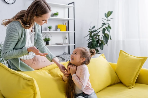 Мама разговаривает с ребенком на диване дома — стоковое фото