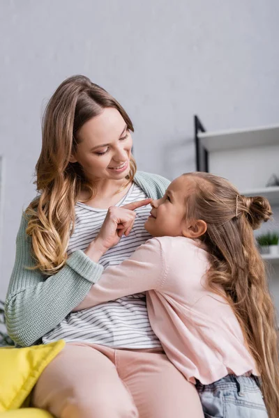 Sonriente madre tocando la nariz del niño - foto de stock