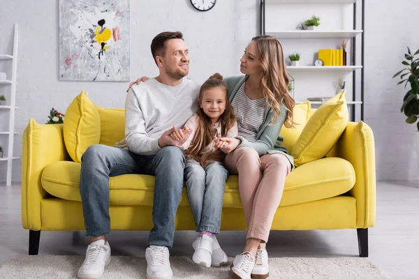 Woman hugging husband and holding hand of daughter — Stock Photo