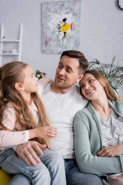 Happy parents looking at daughter in living room — Stock Photo