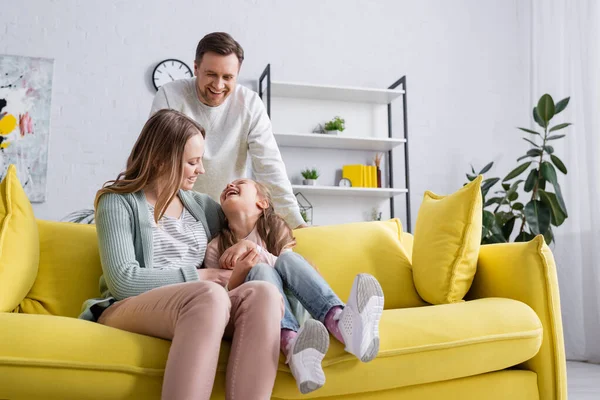 Genitori sorridenti trascorrere del tempo con la figlia a casa — Foto stock