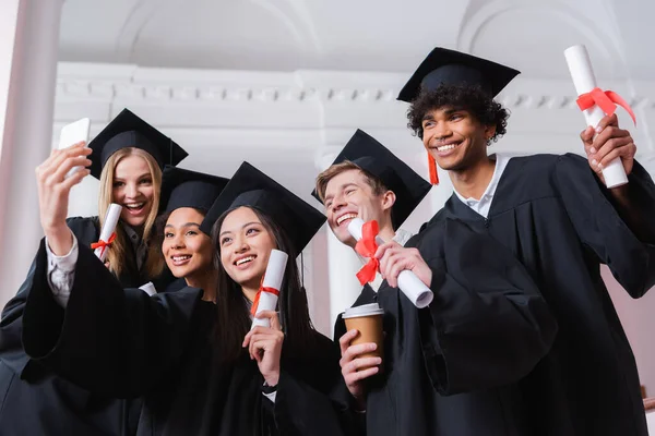 Joyeux célibataires multiethniques prenant selfie sur smartphone — Photo de stock