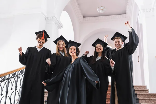 Laureati multietnici che mostrano sì gesto all'università — Foto stock