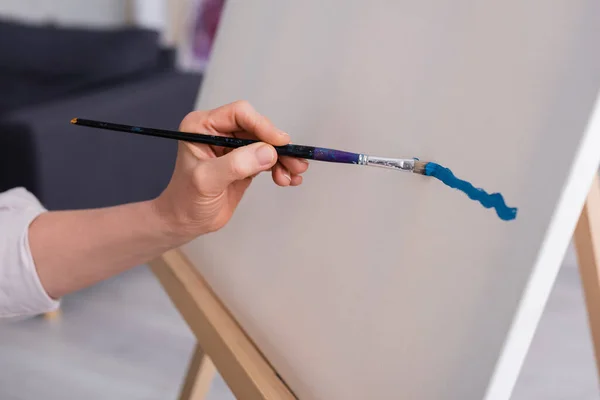 Ausgeschnittene Ansicht einer Frau mittleren Alters mit Pinsel beim Malen auf Leinwand — Stockfoto