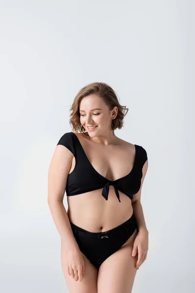 Happy overweight woman in black swimsuit isolated on white — Stock Photo
