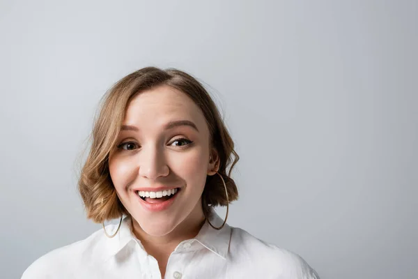 Excited overweight woman in white shirt looking at camera isolated on grey — Stock Photo