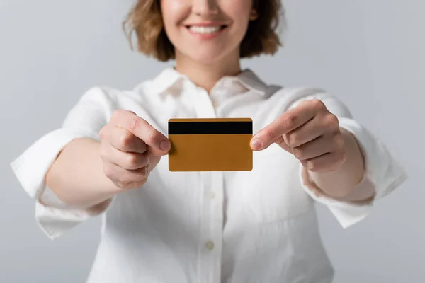 Vue recadrée de la femme heureuse plus la taille tenant la carte de crédit isolée sur gris — Photo de stock