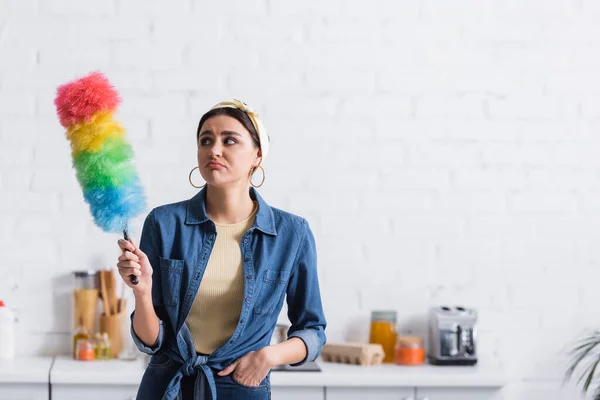 Sconvolto casalinga guardando spazzola di polvere a casa — Foto stock