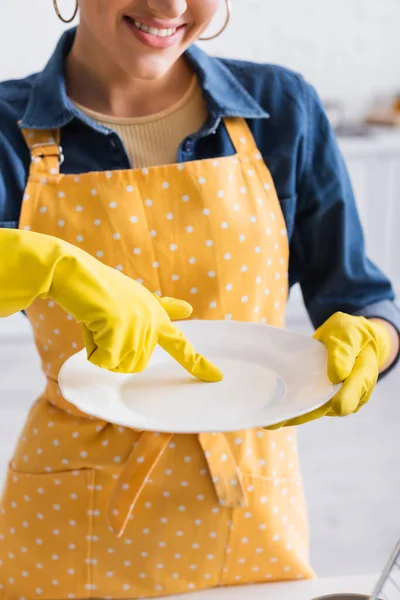 Vue recadrée d'une femme souriante tenant une assiette propre — Photo de stock