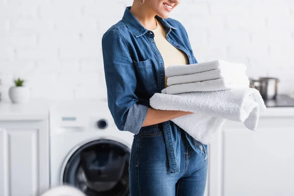 Vista cortada de sorrir dona de casa segurando toalhas limpas — Fotografia de Stock