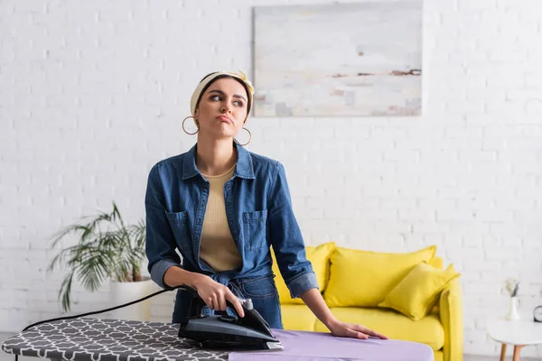 Upset housewife ironing clothes in living room — Stock Photo