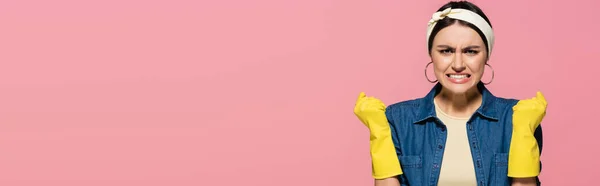 Agresiva ama de casa en guantes de goma aislados en rosa, bandera - foto de stock
