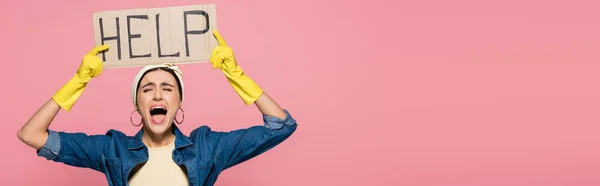Screaming woman in rubber gloves holding placard with help lettering isolated on pink, banner — Stock Photo
