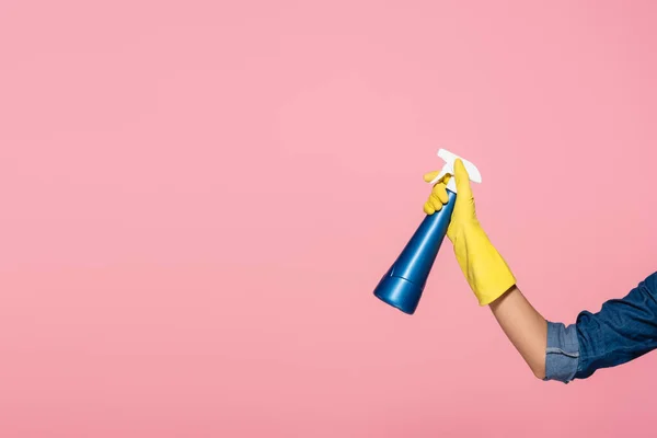 Vista recortada de la mujer en guante de goma que sostiene la botella de detergente aislado en rosa - foto de stock