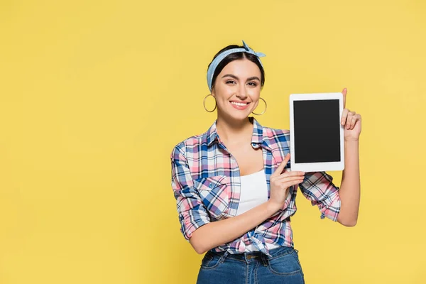 Femme au foyer souriante tenant tablette numérique avec écran blanc isolé sur jaune — Photo de stock