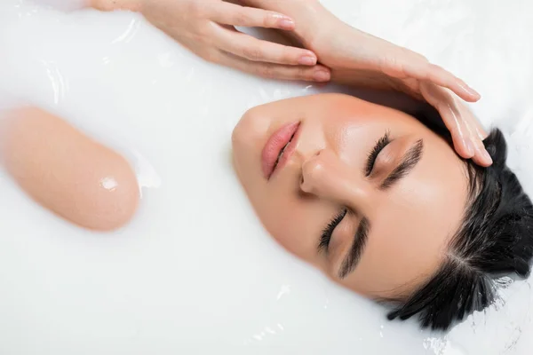 Vista superior de la mujer sensual relajante en baño de leche - foto de stock