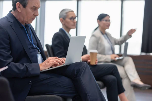 Mature businessman using laptop in conference room — Stock Photo