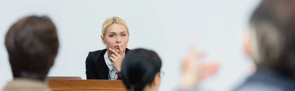 Вдумчивый лектор, смотрящий на размытую аудиторию во время деловой конференции, баннер — стоковое фото