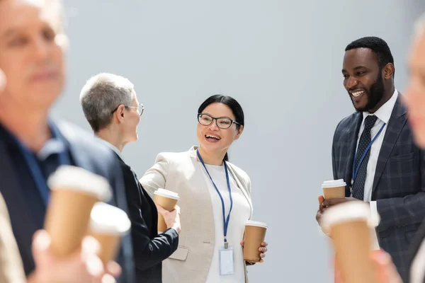 Selective focus of happy interracial business colleagues talking during conference — Stock Photo