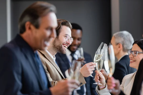 Selektiver Fokus eines jungen Geschäftsmannes, der mit einer asiatischen Geschäftsfrau Champagner trinkt — Stockfoto