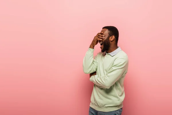 Schockierter afrikanisch-amerikanischer Mann verdeckt Augen auf rosa Hintergrund — Stockfoto