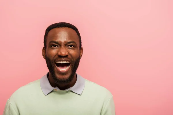 Allegro uomo afroamericano che guarda in alto isolato sul rosa — Foto stock