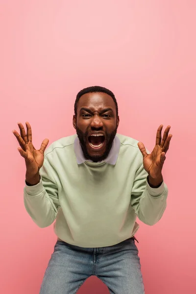 Schreiender afrikanisch-amerikanischer Mann schaut in die Kamera auf rosa Hintergrund — Stockfoto