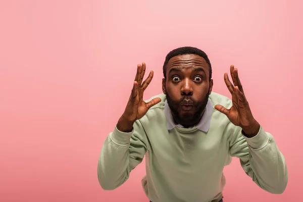 Schockierter Afroamerikaner blickt isoliert auf rosa Kamera mit Kopierraum — Stockfoto