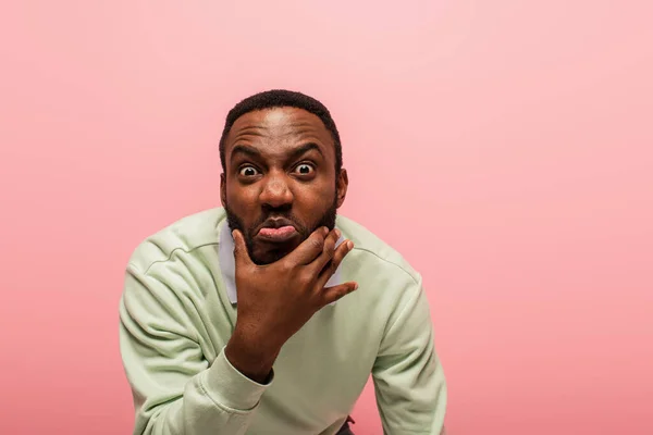 Afro-Américain grimaçant à la caméra isolé sur rose — Photo de stock